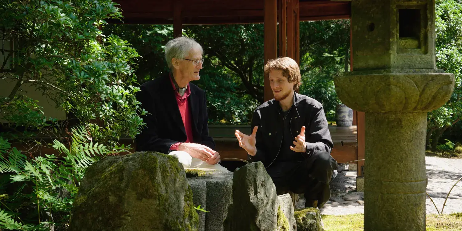 Prof. Dr. Wybe Kuitert and head gardener Levi Schilperoordt in conversation beside a stone lantern at Clingendael.