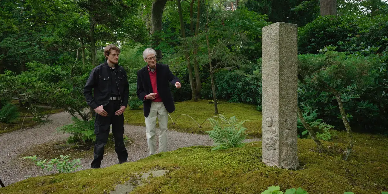 Prof. Dr. Wybe Kuitert and head gardener Levi Schilperoordt at a carved stone pillar.