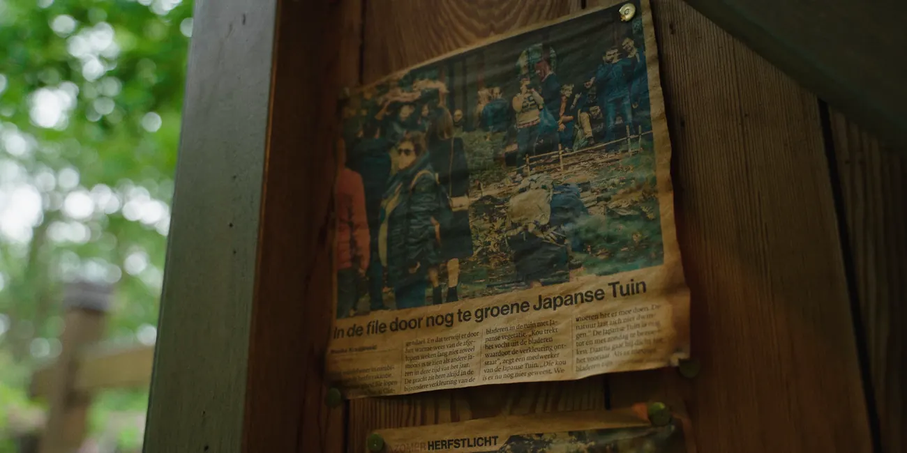 A newspaper cutting about the garden, pinned to a wooden post.